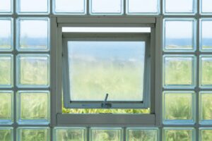 Open window in glass block wall overlooking landscape