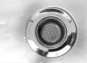 Filtre de douche chromé avec motif de trous hexagonaux.