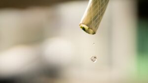 Goutte d'eau suspendue à l'extrémité d'un tuyau.
