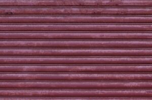 Motifs de lignes horizontales rougeâtres sur une surface texturée.