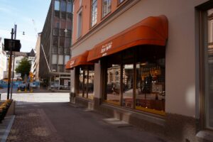 Bâtiment commercial avec enseigne orange et fenêtres vitrées.