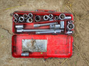 Boîte à outils rouge contenant des clés et des outils de réparation.