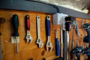Outils de bricolage suspendus sur un mur en bois.