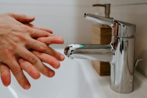 Mains se lavant sous un robinet d'eau.