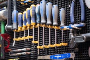 Assortiment d'outils de bricolage et de réparation, organisés sur un panneau perforé.