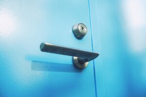 Poignée de porte bleue avec serrure en métal.