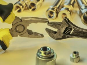 Outils de réparation et de construction en métal sur fond jaune.