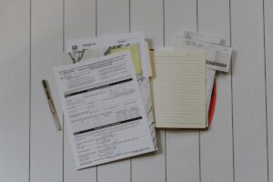Formulaires, documents, stylo et papier sur un bureau en bois.