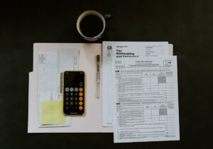 Bureau avec documents fiscaux, calculatrice et tasse de café.