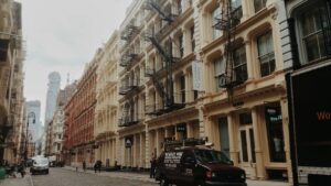 Rues de New York avec bâtiments historiques et voitures garées.