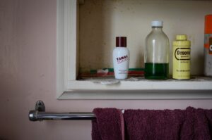 Étagère avec produits de toilette et serviette de bain violette.