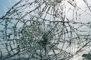 Verre brisé avec des fissures complexes et un motif radial.